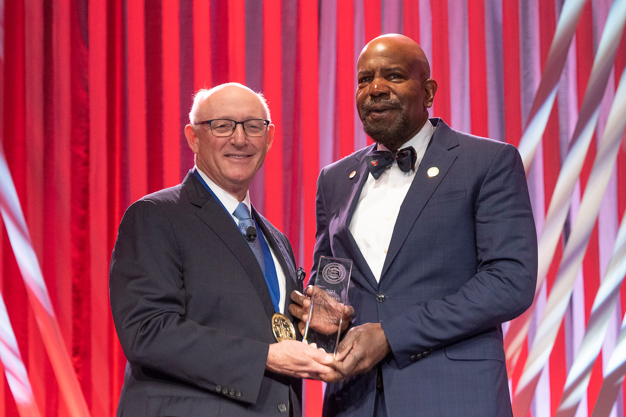 Dr. Cato T. Laurencin receiving the 2022 Diversity Award by AAOS President Daniel K. Guy, MD, FAAOS during the American Academy of Orthopaedic Surgeons (AAOS) 2022 Annual meeting at the McCormick Convention Center in Chicago on March 24, 2022. The conference is the preeminent meeting on musculoskeletal education to orthopaedic surgeons and allied health professionals in the world ( Photo by © AAOS/Todd Buchanan 2022).